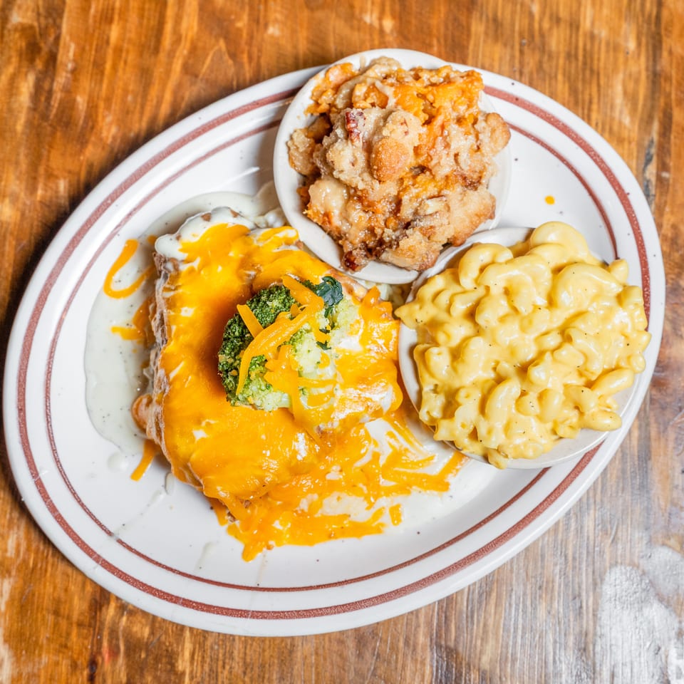 Entree with melted cheese and broccoli, mac and cheese, and a sweet potato crumble.